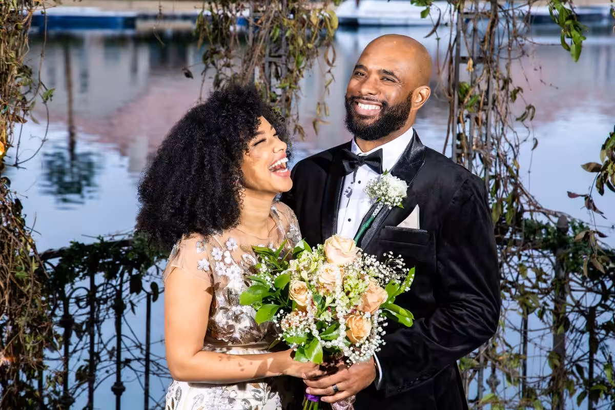 Bride and groom smiling by the lake