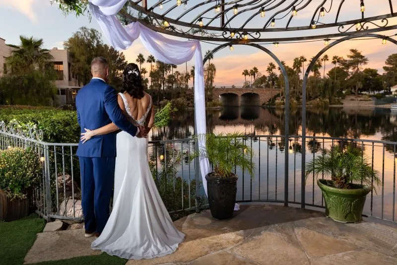 Bride and groom at an evening lakeside ceremony under a gazebo